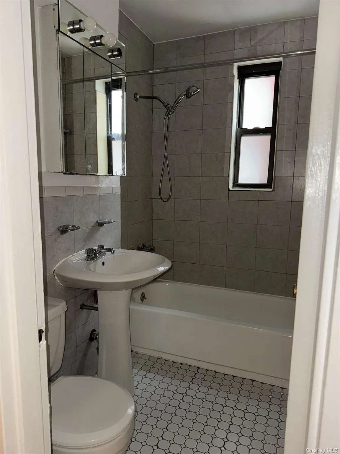 Full bathroom featuring tub / shower combination, tile walls, tile patterned flooring, and decorative backsplash Full bathroom featuring tub / shower combination, tile walls, tile patterned flooring, and decorative backsplash