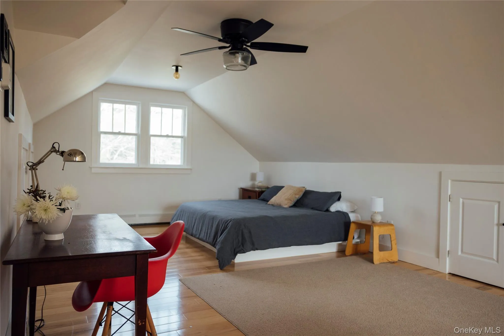 Bedroom featuring baseboard heating, baseboards, wood finished floors, and lofted ceiling Bedroom featuring baseboard heating, baseboards, wood finished floors, and lofted ceiling