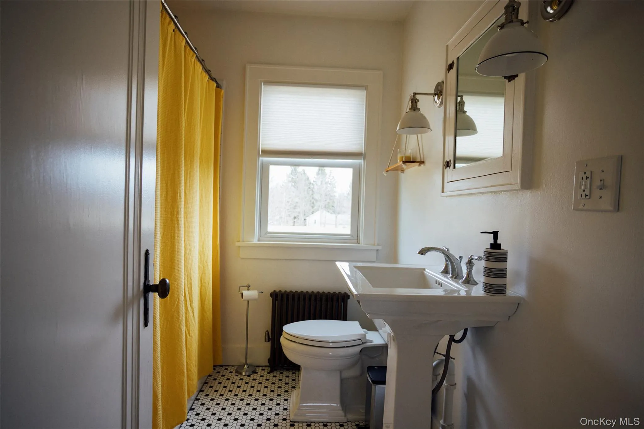 Bathroom with radiator heating unit, toilet, and curtained shower Bathroom with radiator heating unit, toilet, and curtained shower