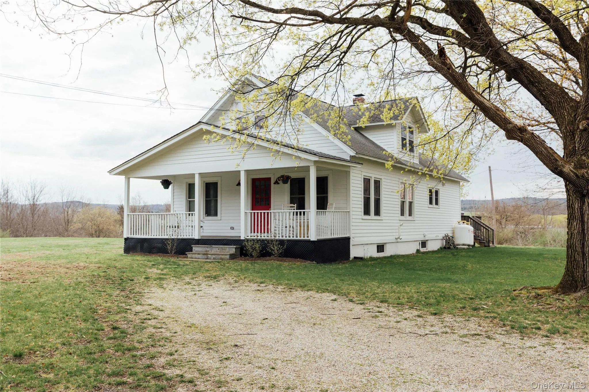 View of front of house with covered porch, a chimney, a shingled roof, and a front yard View of front of house with covered porch, a chimney, a shingled roof, and a front yard