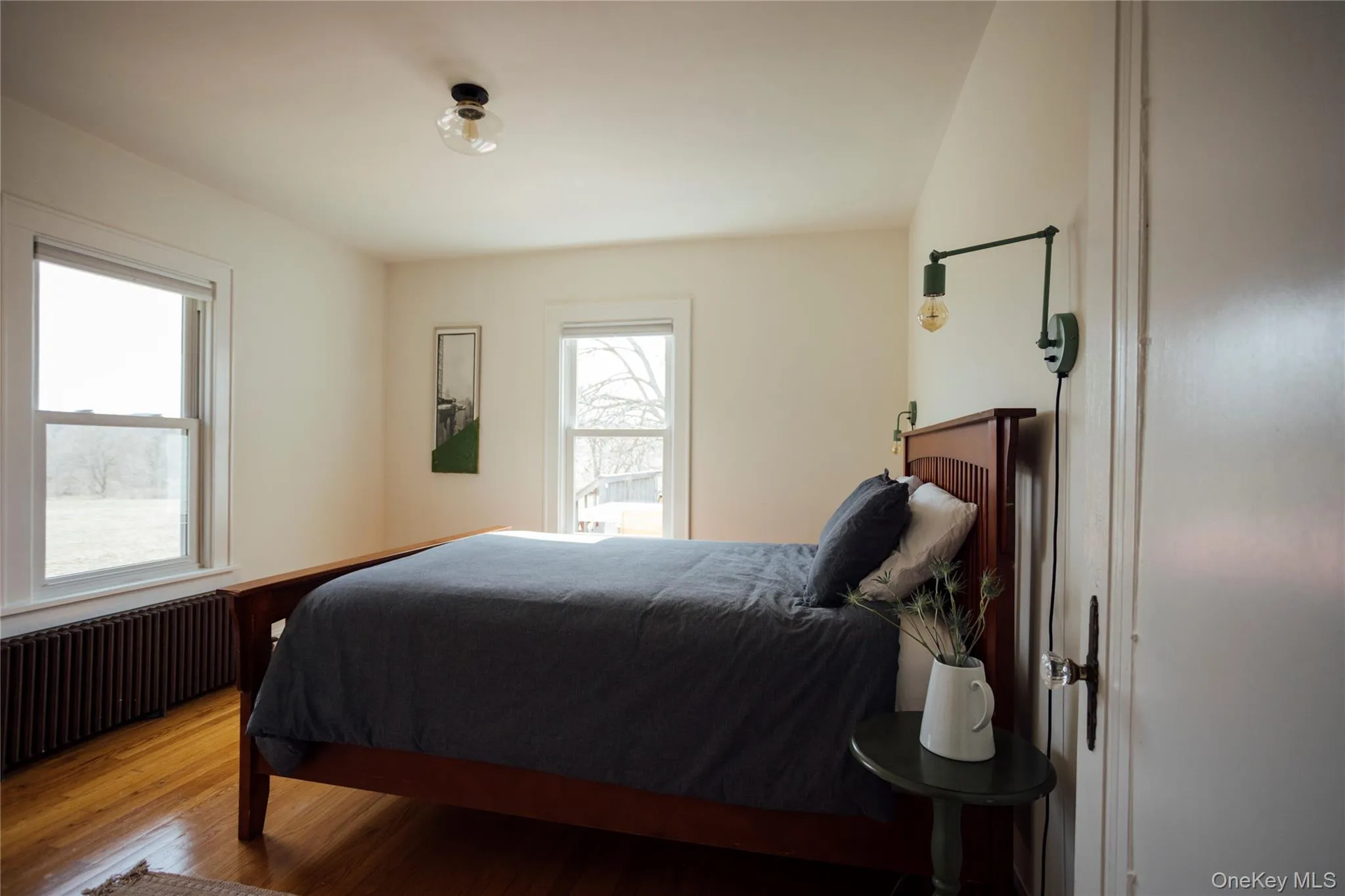 Bedroom with radiator and wood finished floors Bedroom with radiator and wood finished floors