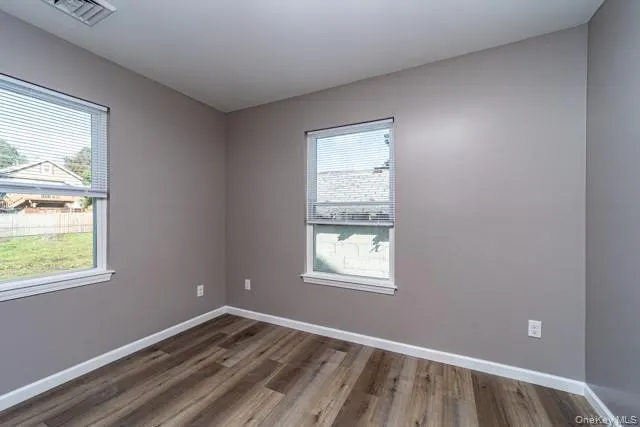Empty room with baseboards and wood finished floors Empty room with baseboards and wood finished floors