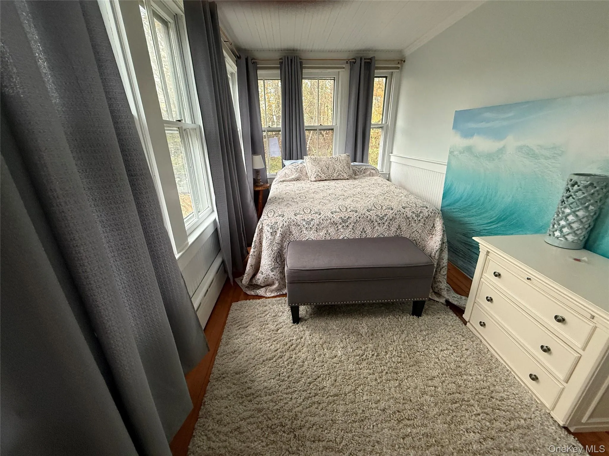 Bedroom with a wainscoted wall and a baseboard radiator Bedroom with a wainscoted wall and a baseboard radiator