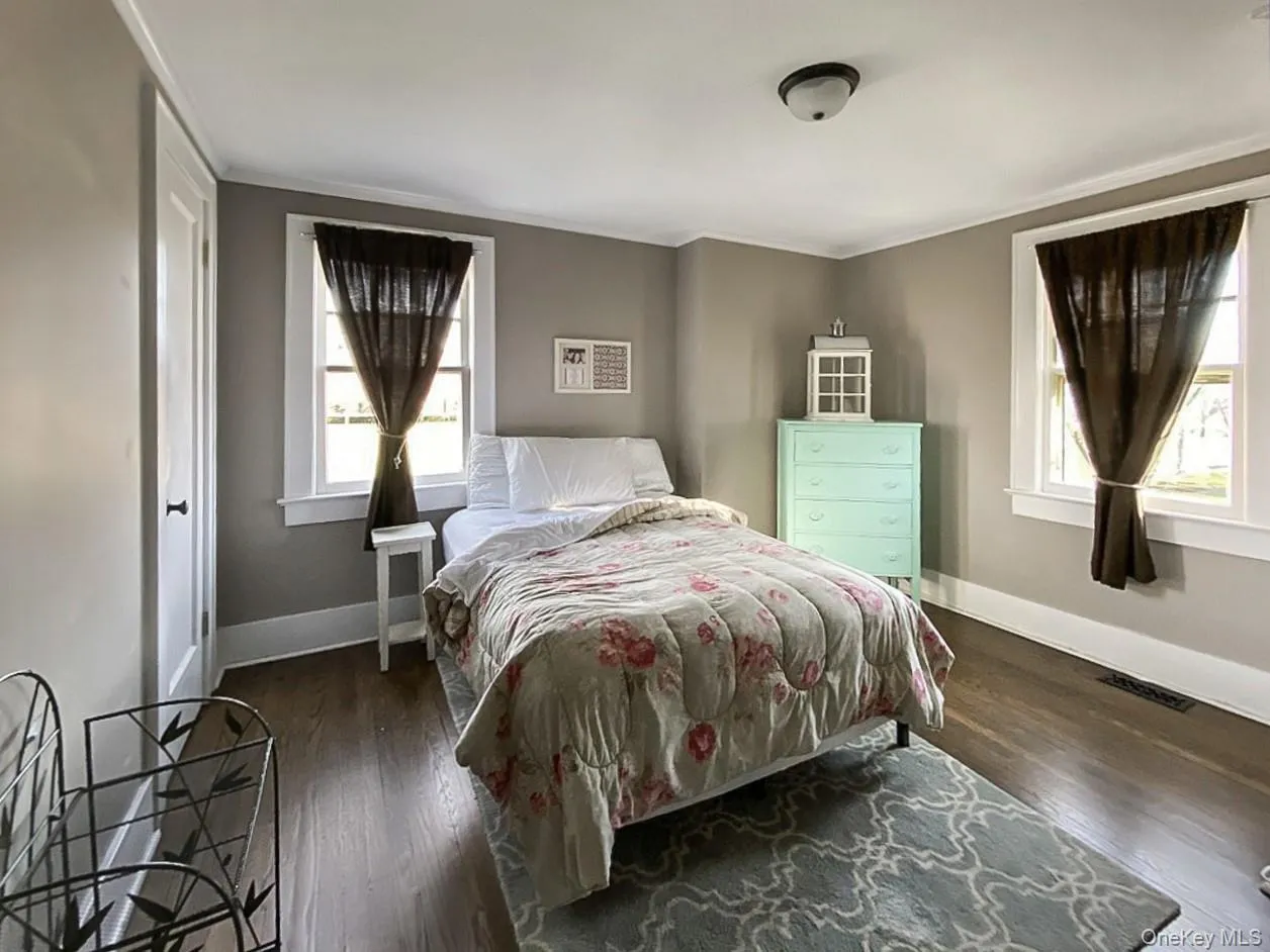 Bedroom with dark wood-style floors and crown molding Bedroom with dark wood-style floors and crown molding