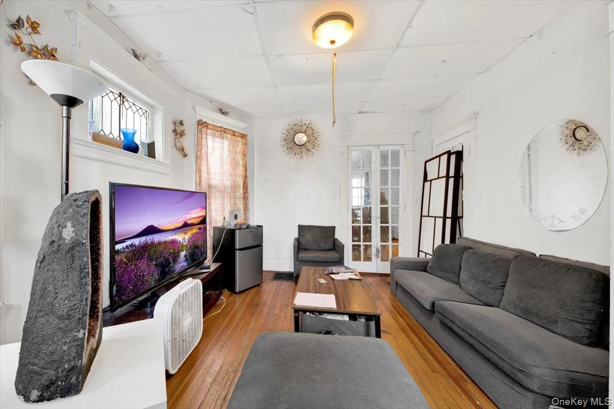 Living room with hardwood / wood-style floors and a paneled ceiling Living room with hardwood / wood-style floors and a paneled ceiling