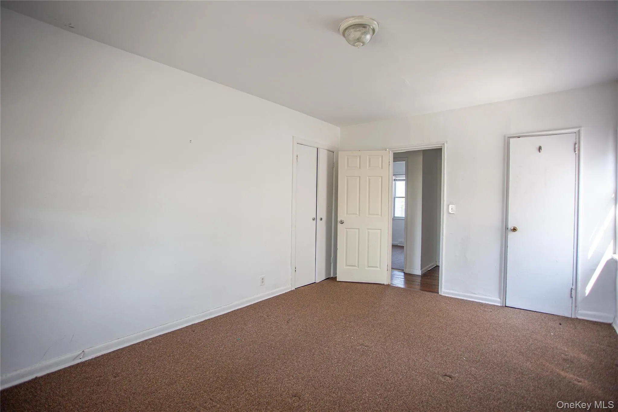 Unfurnished bedroom with carpet flooring and baseboards Unfurnished bedroom with carpet flooring and baseboards