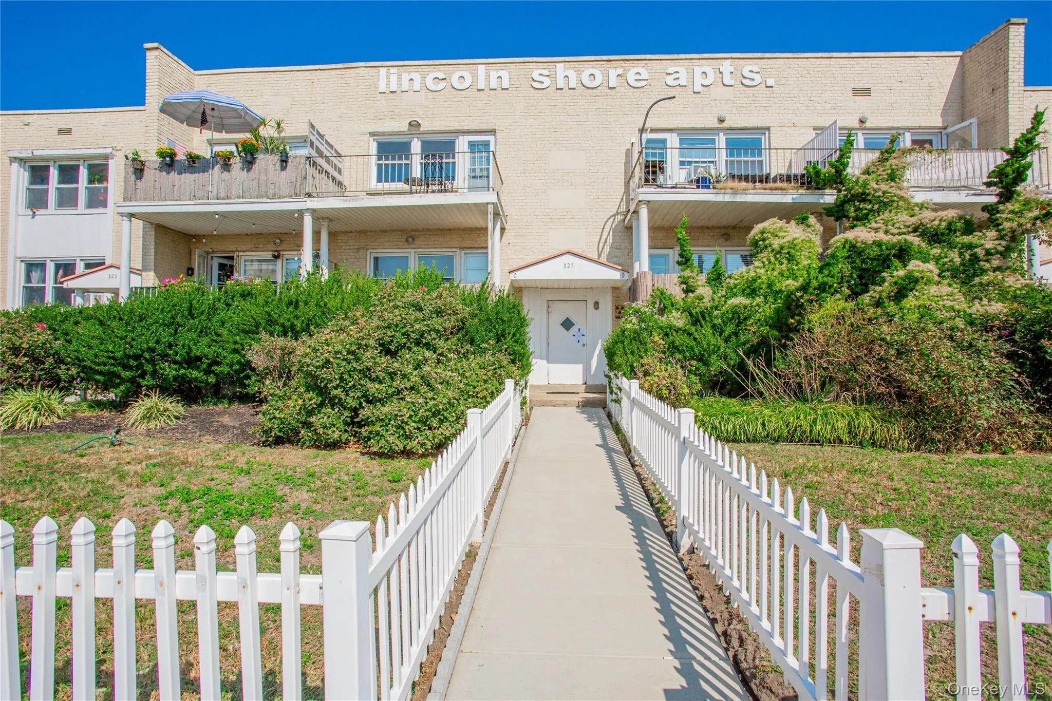 View of front of property with brick siding and a balcony View of front of property with brick siding and a balcony