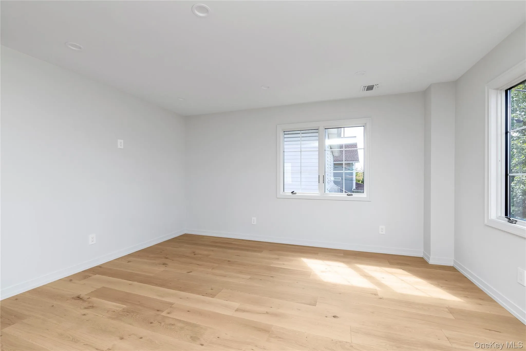 Spare room featuring light wood finished floors and baseboards Spare room featuring light wood finished floors and baseboards
