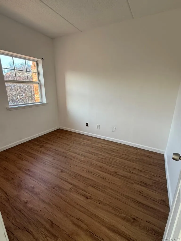 Spare room with dark wood-style flooring and a textured ceiling Spare room with dark wood-style flooring and a textured ceiling