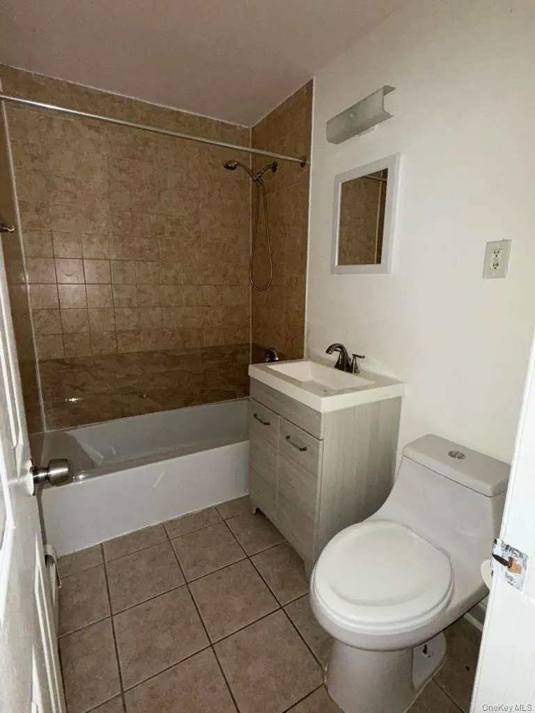 Bathroom with vanity, light tile patterned floors, and bathing tub / shower combination Bathroom with vanity, light tile patterned floors, and bathing tub / shower combination