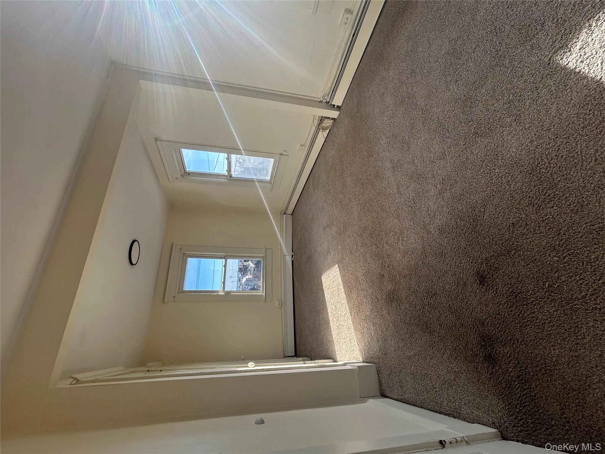 Carpeted empty room featuring baseboards and a baseboard heating unit Carpeted empty room featuring baseboards and a baseboard heating unit