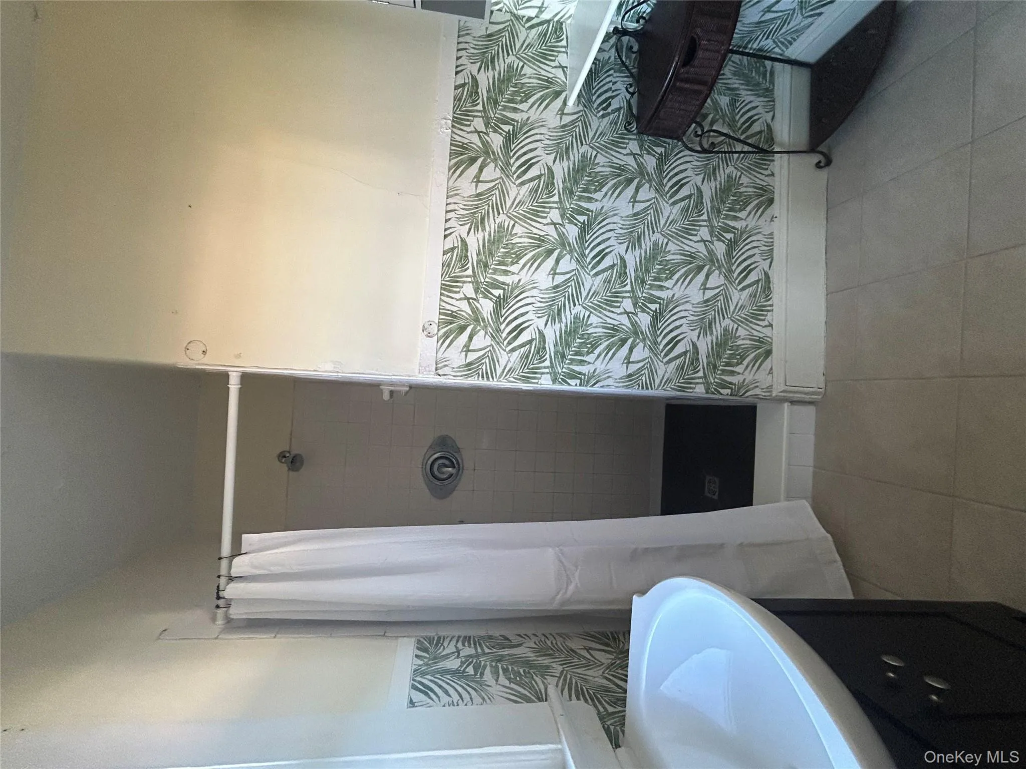 Full bathroom with vanity, a stall shower, a wainscoted wall, light tile patterned flooring, and wallpapered walls Full bathroom with vanity, a stall shower, a wainscoted wall, light tile patterned flooring, and wallpapered walls