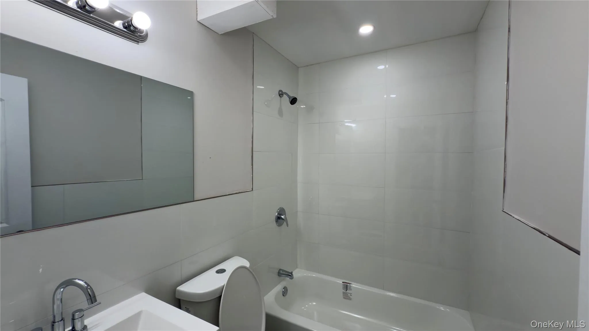 Full bathroom with shower combination, vanity, and tile walls Full bathroom with shower combination, vanity, and tile walls