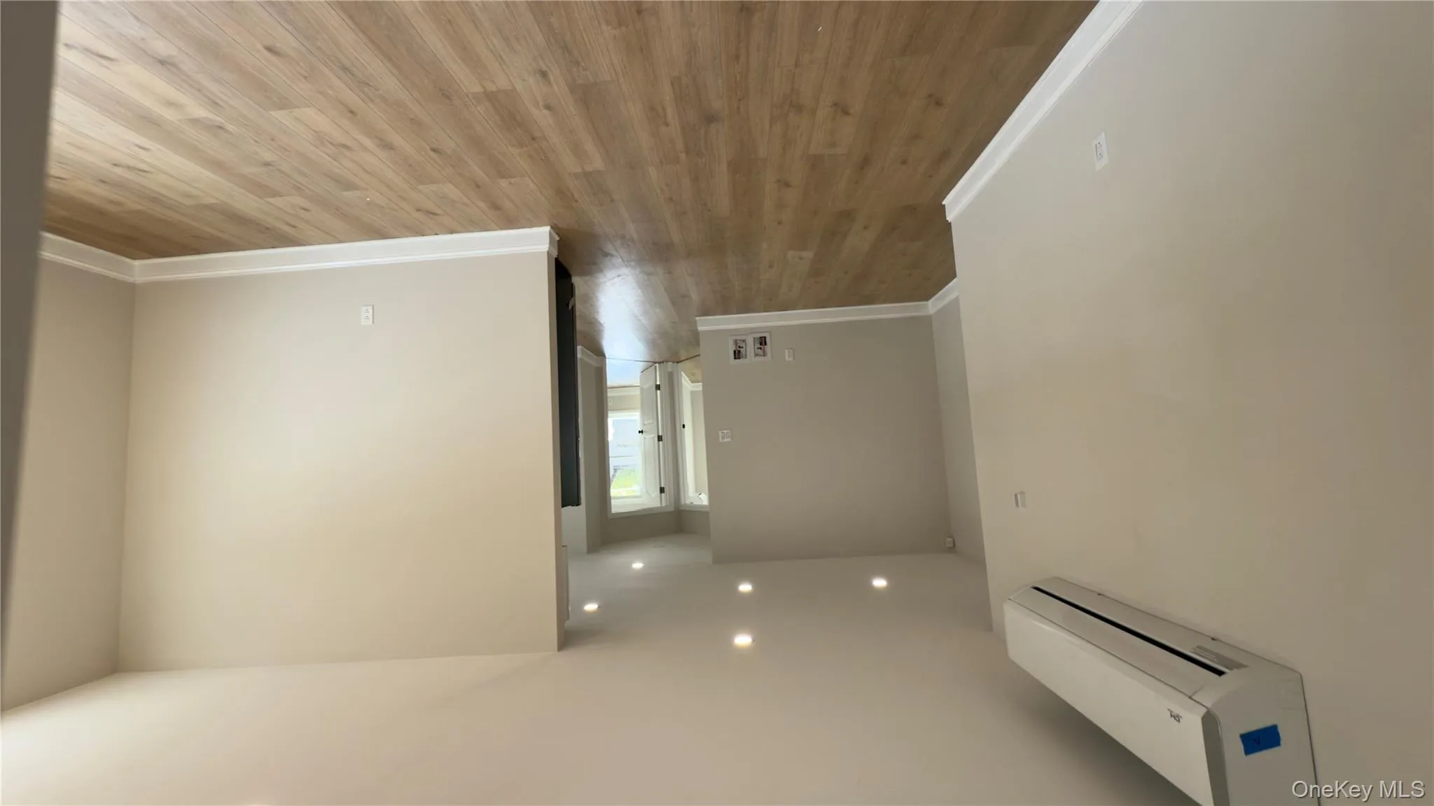 Empty room featuring wood ceiling, a wall unit AC, and crown molding Empty room featuring wood ceiling, a wall unit AC, and crown molding