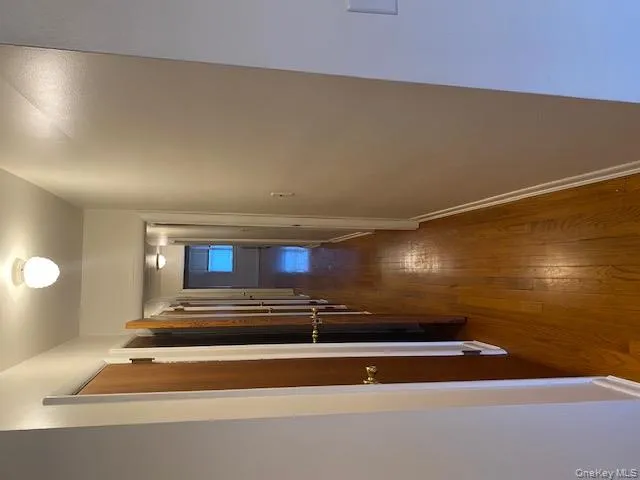 Hall featuring dark wood finished floors and baseboards Hall featuring dark wood finished floors and baseboards