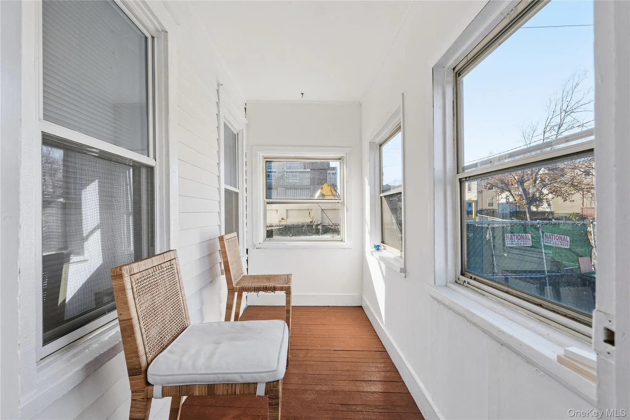 Sunroom featuring baseboards and hardwood / wood-style floors Sunroom featuring baseboards and hardwood / wood-style floors