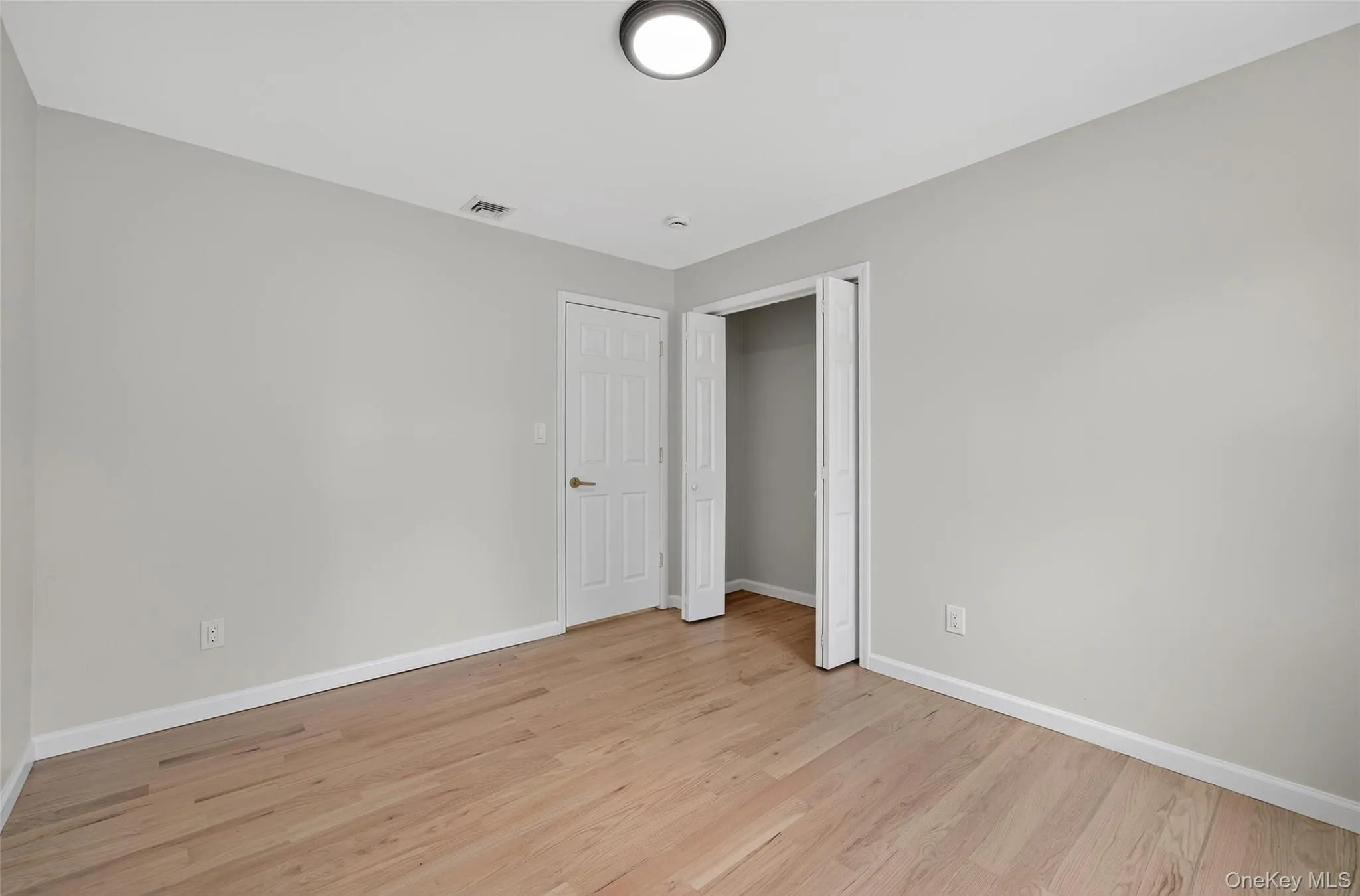 Unfurnished bedroom featuring light wood-style flooring and a closet Unfurnished bedroom featuring light wood-style flooring and a closet