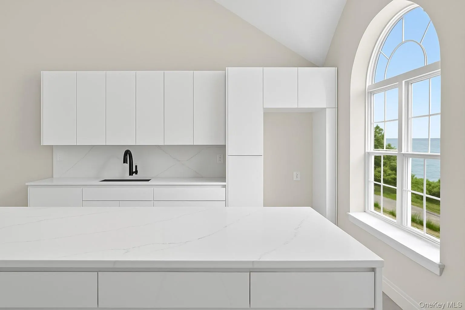 Kitchen featuring modern cabinets, white cabinetry, a water view, light stone countertops, and lofted ceiling Kitchen featuring modern cabinets, white cabinetry, a water view, light stone countertops, and lofted ceiling