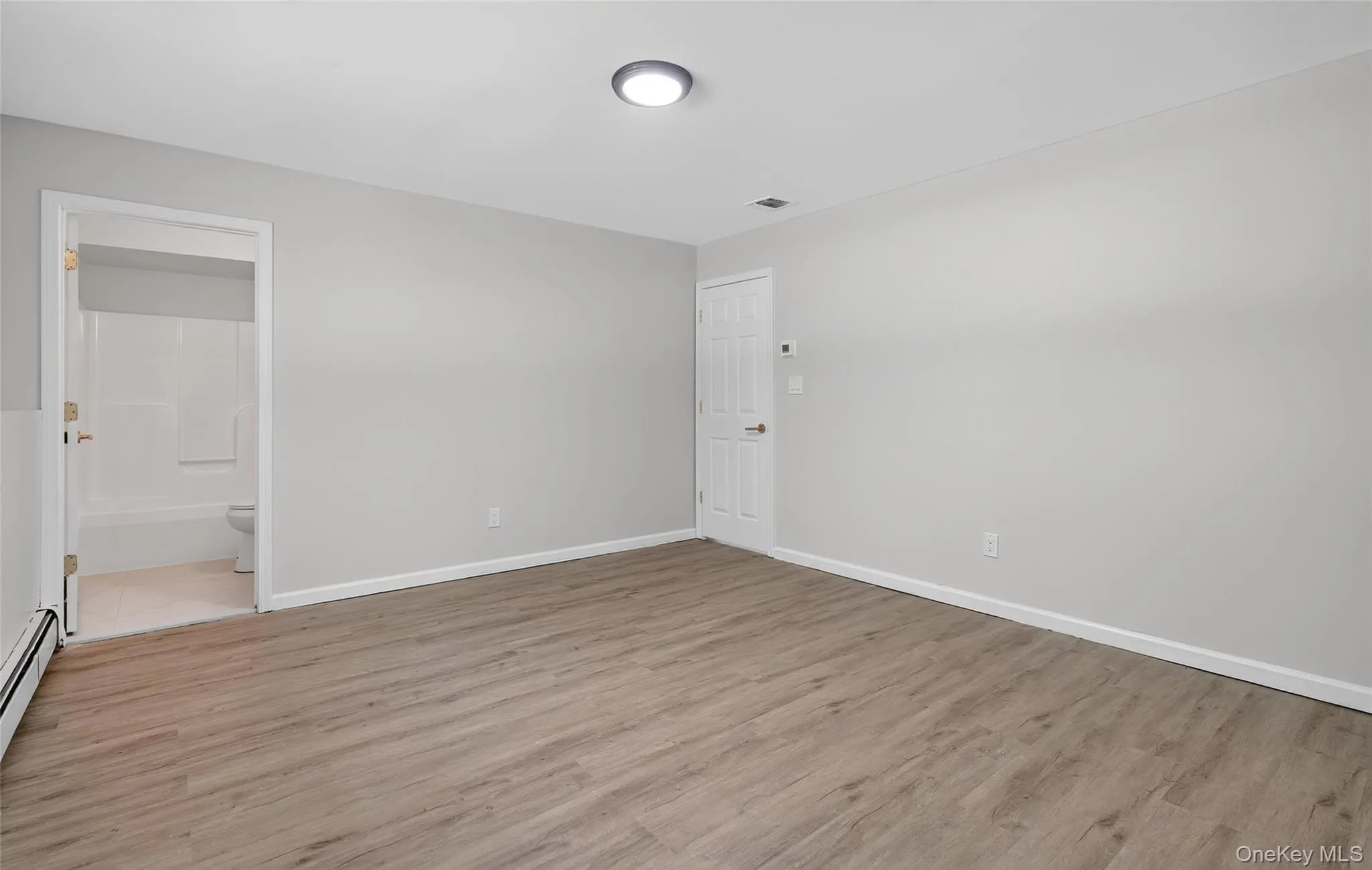 Spare room with light wood-type flooring and baseboard heating Spare room with light wood-type flooring and baseboard heating