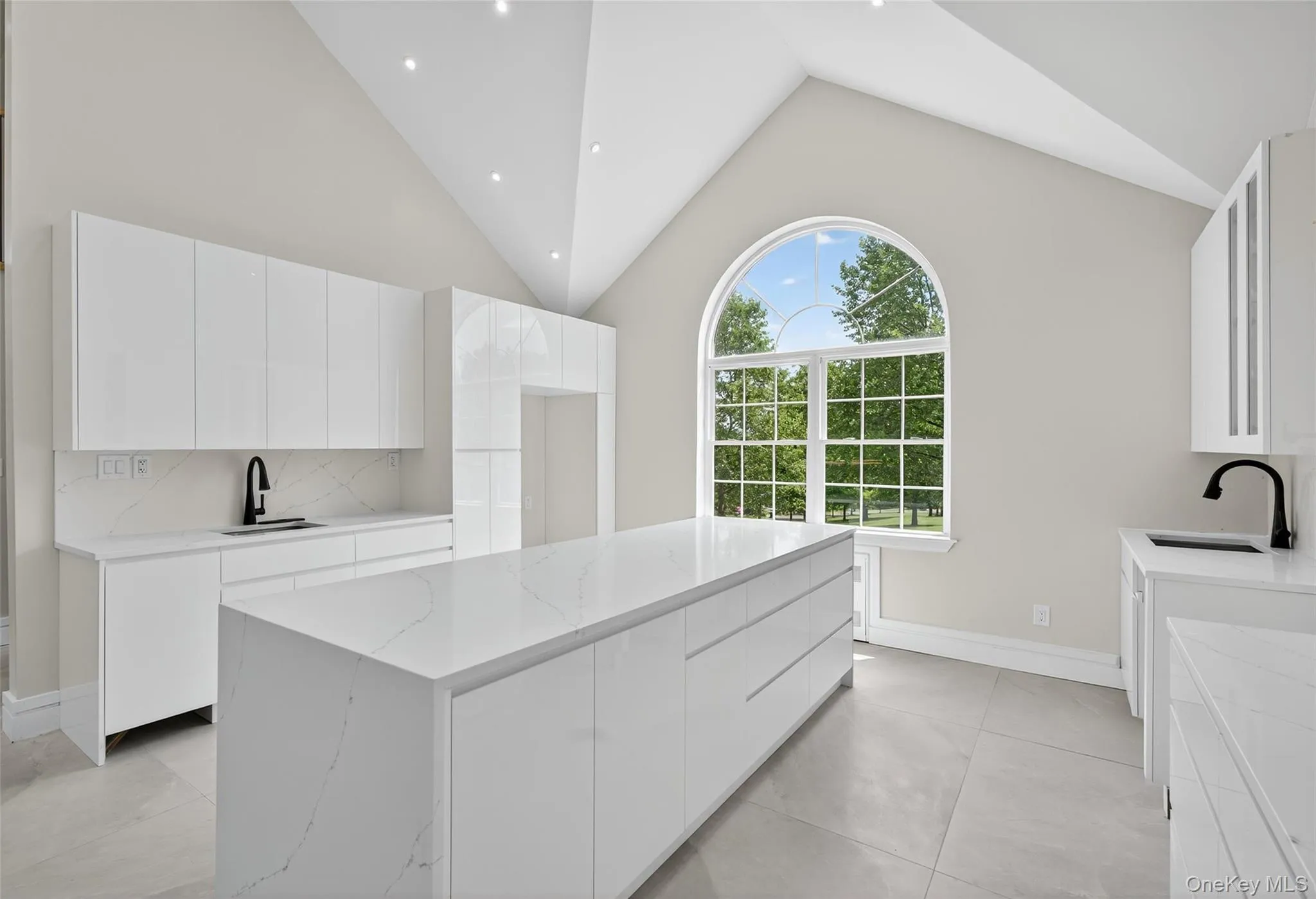 Kitchen featuring light stone countertops, backsplash, white cabinetry, a center island, and recessed lighting Kitchen featuring light stone countertops, backsplash, white cabinetry, a center island, and recessed lighting