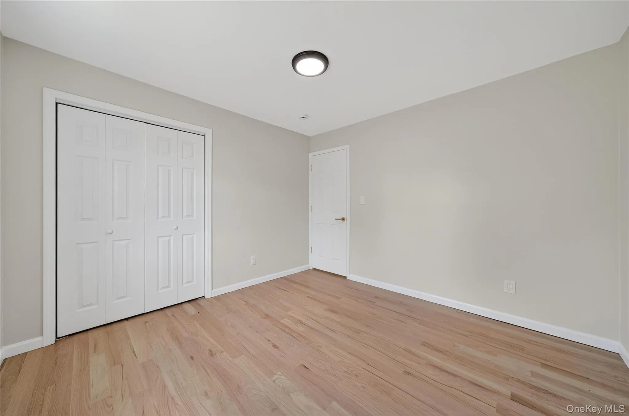 Unfurnished bedroom featuring light wood-style flooring and a closet Unfurnished bedroom featuring light wood-style flooring and a closet
