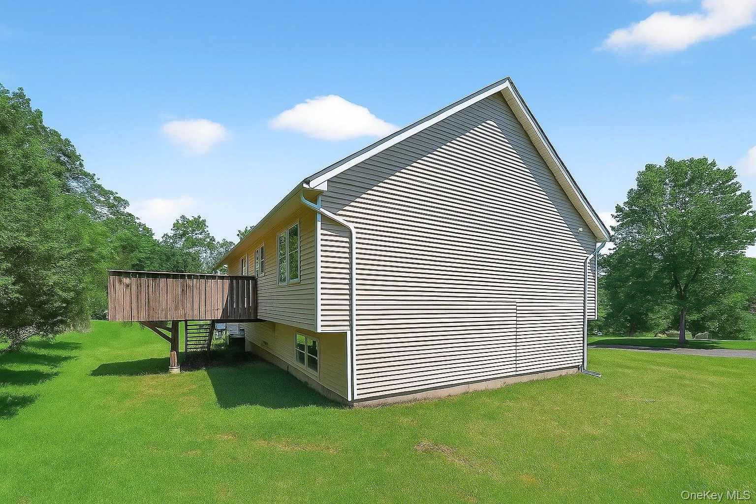 View of side of home with a lawn and a deck View of side of home with a lawn and a deck
