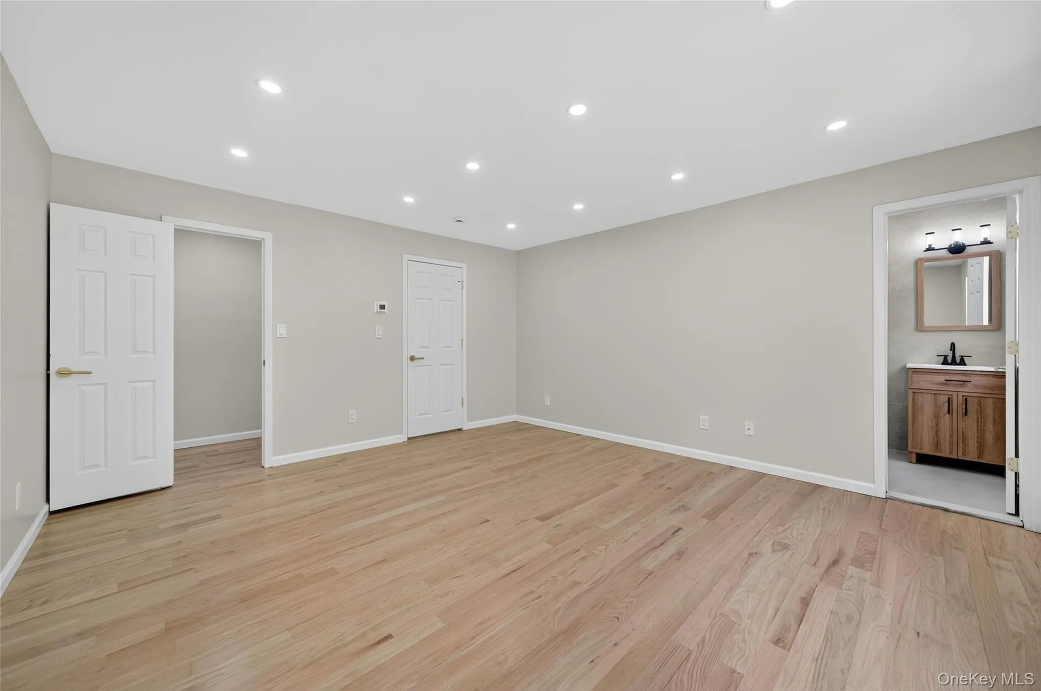 Unfurnished bedroom featuring light wood-style flooring, recessed lighting, and ensuite bath Unfurnished bedroom featuring light wood-style flooring, recessed lighting, and ensuite bath