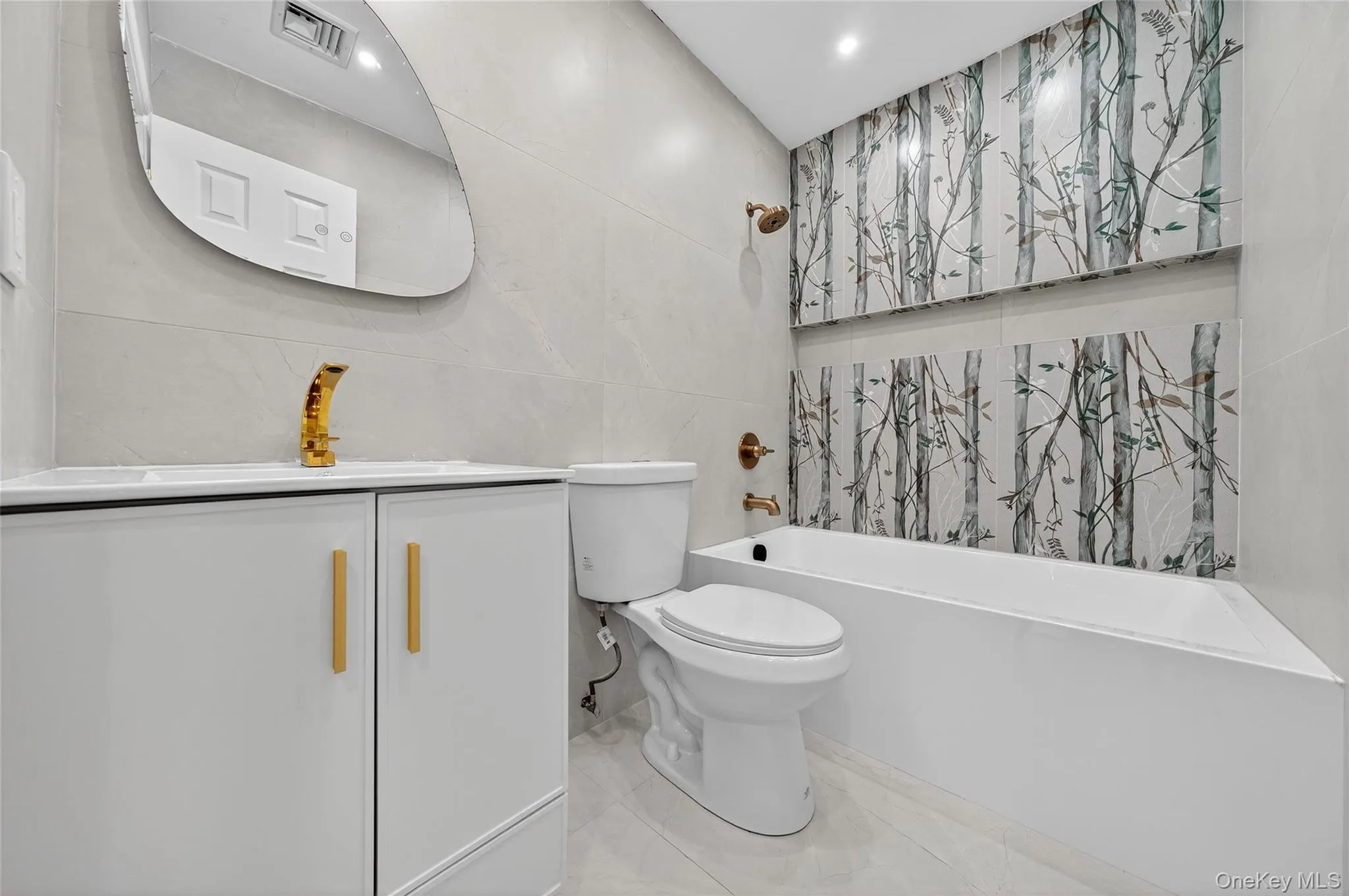 Full bathroom featuring tile walls, vanity, shower / tub combination, and tile patterned floors Full bathroom featuring tile walls, vanity, shower / tub combination, and tile patterned floors