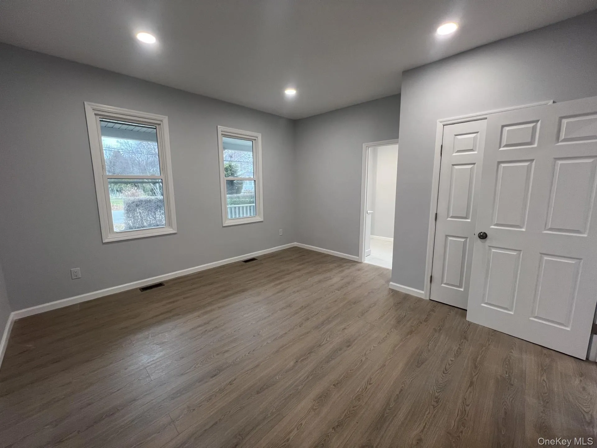Unfurnished bedroom with dark wood finished floors, a closet, and recessed lighting Unfurnished bedroom with dark wood finished floors, a closet, and recessed lighting