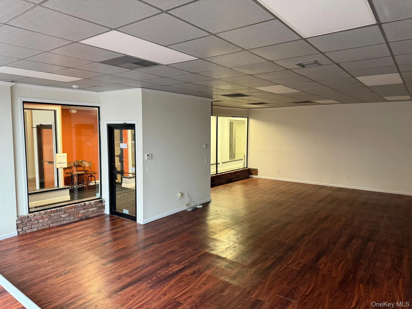 Empty room with dark wood finished floors and a paneled ceiling Empty room with dark wood finished floors and a paneled ceiling