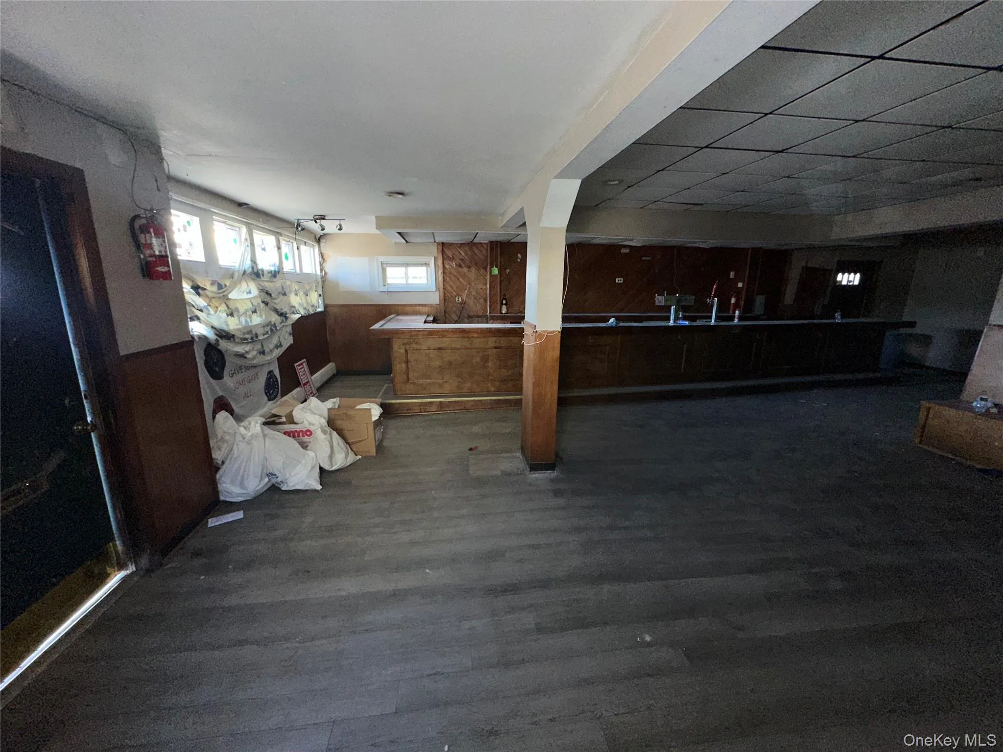 Miscellaneous room featuring wainscoting, dark wood finished floors, and wood walls Miscellaneous room featuring wainscoting, dark wood finished floors, and wood walls