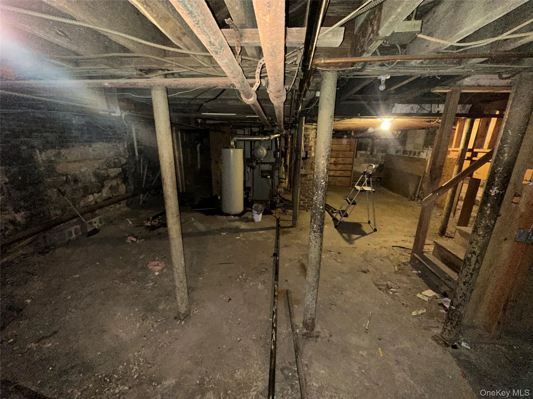 Unfinished below grade area featuring water heater Unfinished below grade area featuring water heater