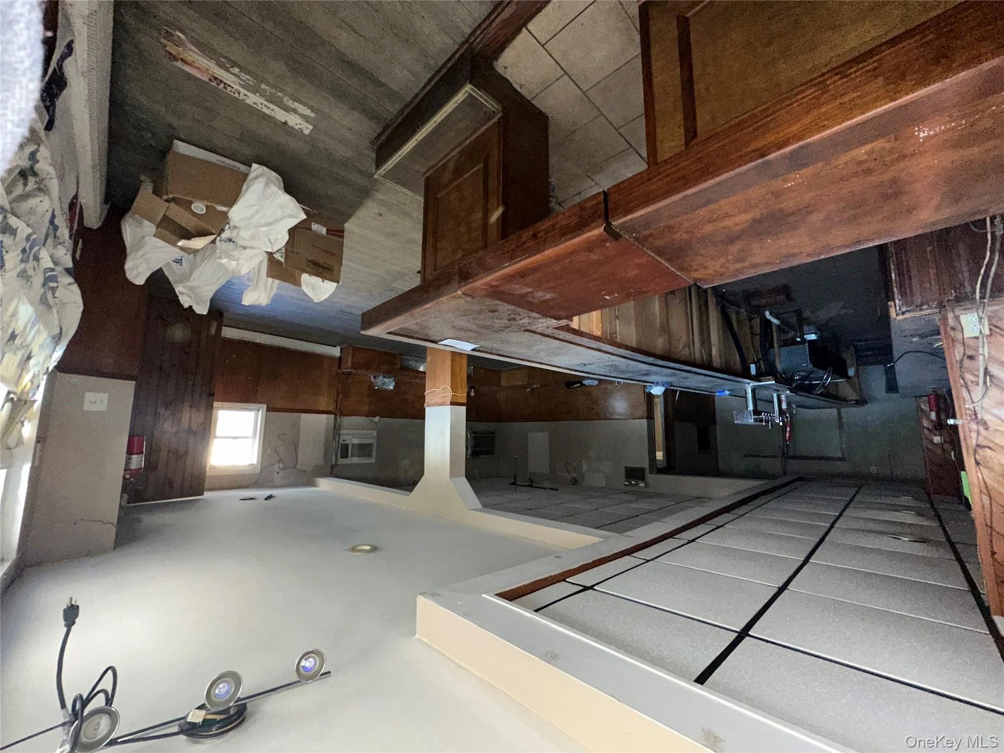 Playroom featuring a wainscoted wall, wood walls, dark wood finished floors, a baseboard heating unit, and a bar Playroom featuring a wainscoted wall, wood walls, dark wood finished floors, a baseboard heating unit, and a bar