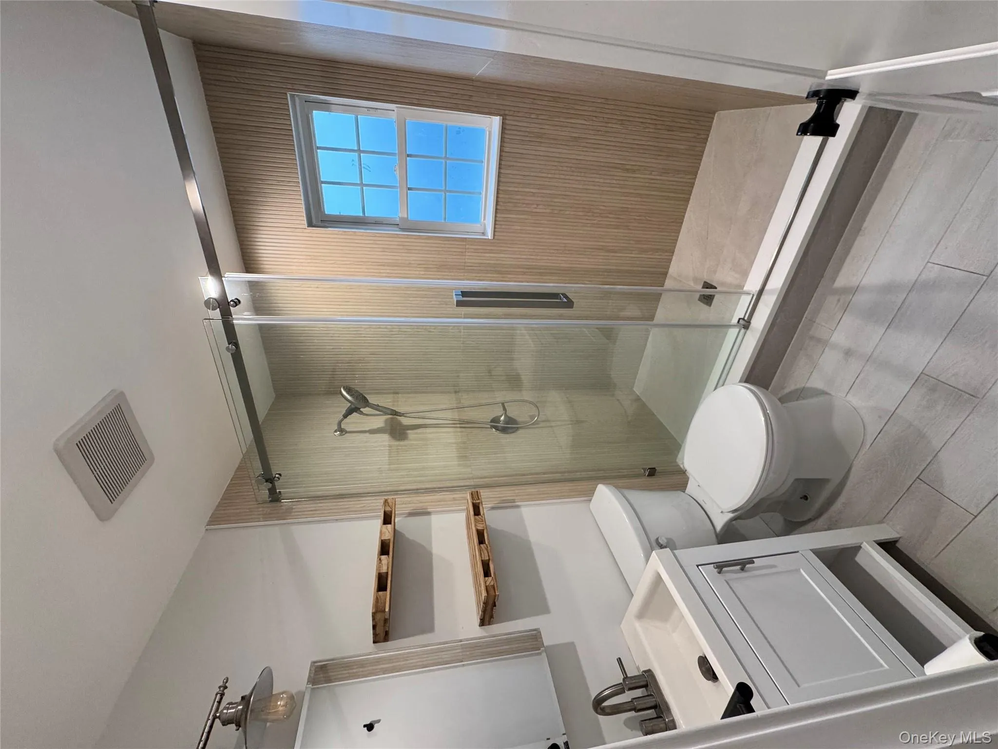 Bathroom with vanity, a stall shower, and light tile patterned floors Bathroom with vanity, a stall shower, and light tile patterned floors