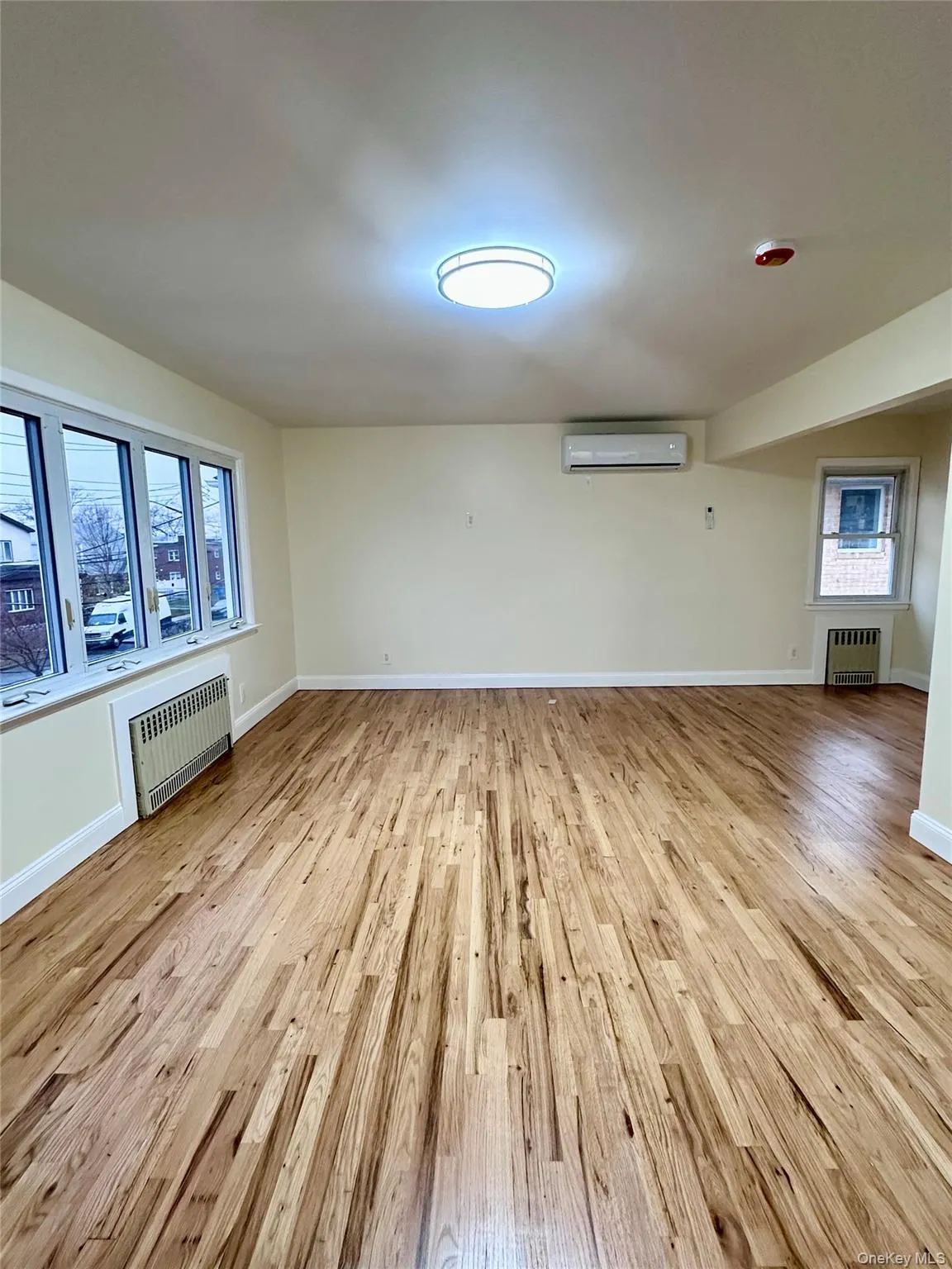Unfurnished room with light wood-style flooring and radiator Unfurnished room with light wood-style flooring and radiator
