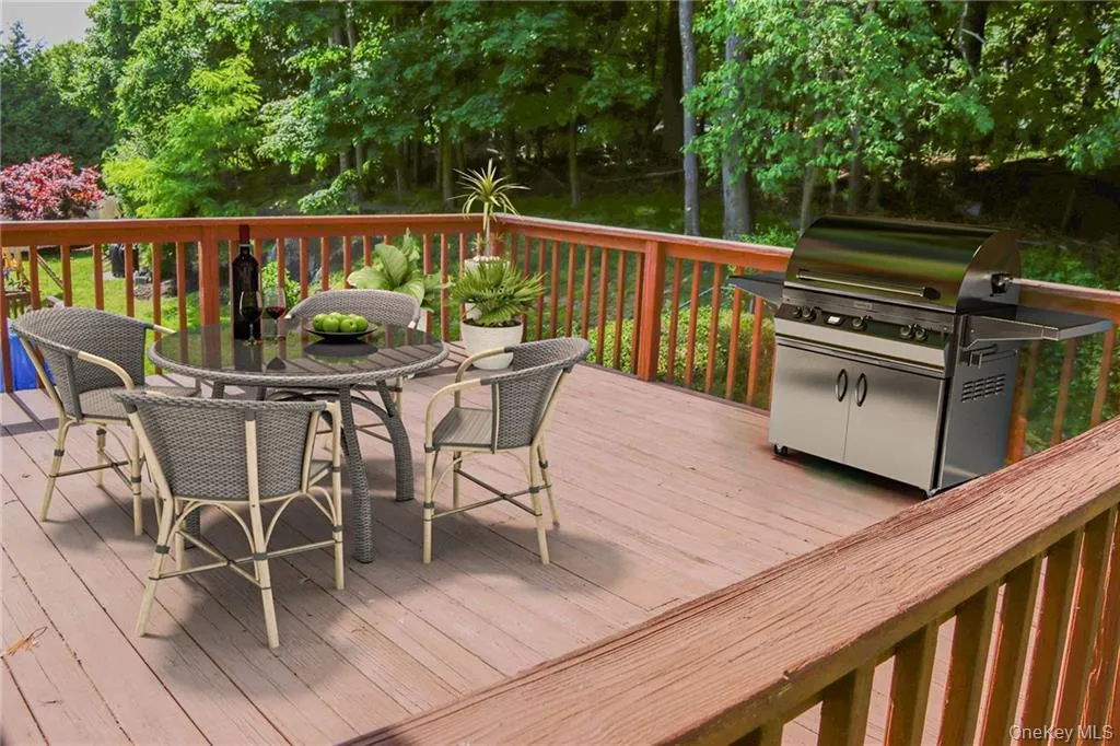 Wooden terrace featuring outdoor dining area and grilling area Wooden terrace featuring outdoor dining area and grilling area
