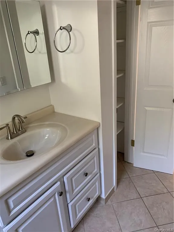 Bathroom featuring vanity and light tile patterned floors Bathroom featuring vanity and light tile patterned floors
