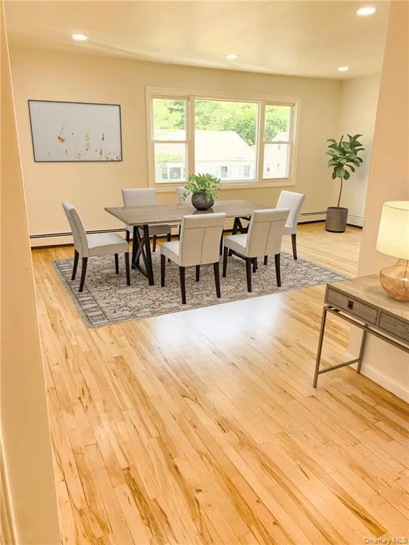 Dining space featuring light wood-type flooring, healthy amount of natural light, recessed lighting, and baseboard heating Dining space featuring light wood-type flooring, healthy amount of natural light, recessed lighting, and baseboard heating