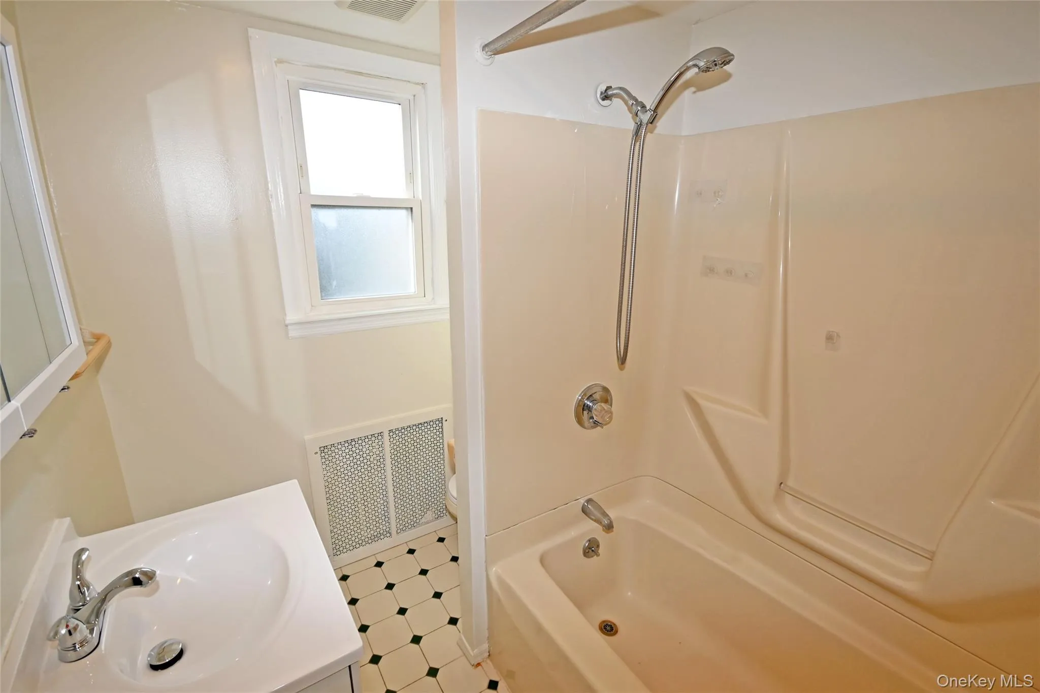 Full bathroom featuring bathing tub / shower combination, vanity, and tile patterned floors Full bathroom featuring bathing tub / shower combination, vanity, and tile patterned floors