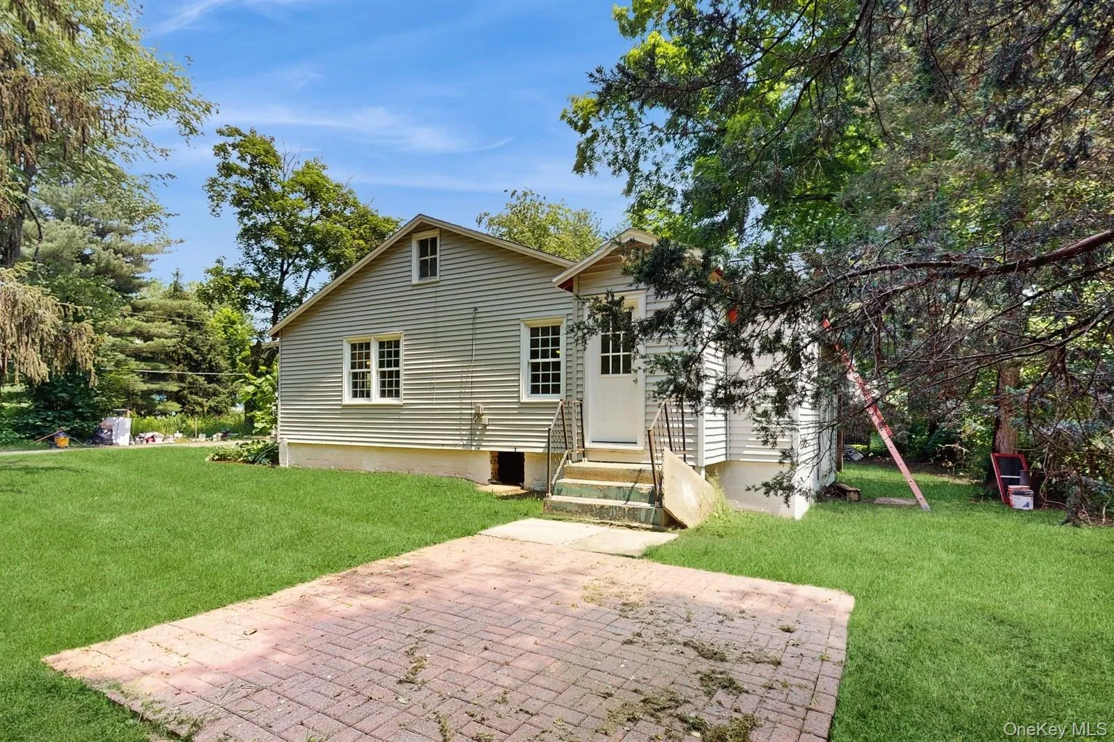 Rear view of house featuring entry steps, a lawn, and a patio Rear view of house featuring entry steps, a lawn, and a patio