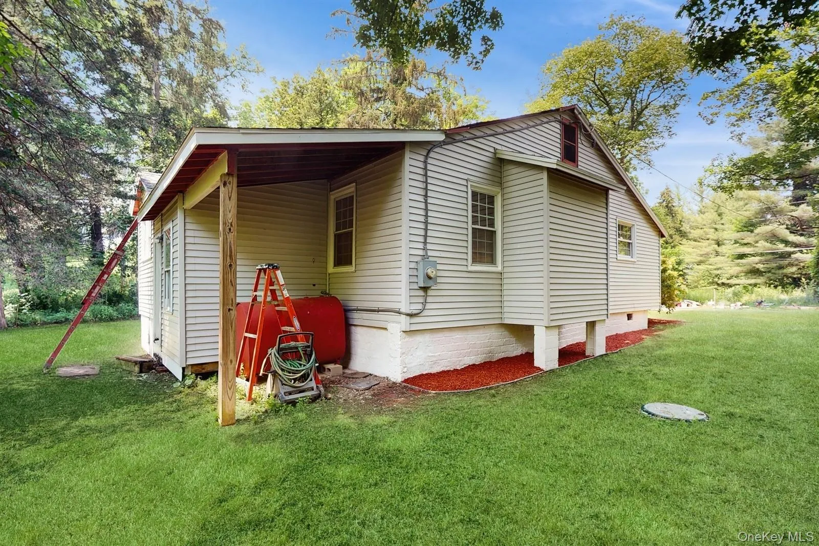View of side of home with a carport, a lawn, oil tank, and crawl space View of side of home with a carport, a lawn, oil tank, and crawl space