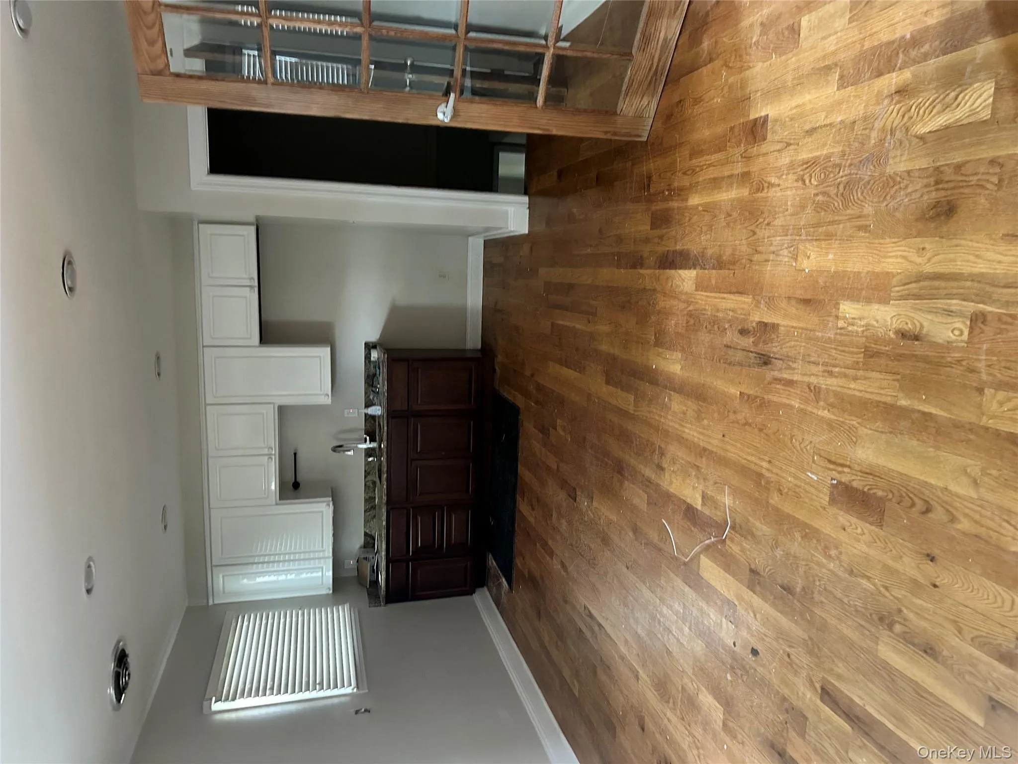 Kitchen featuring white cabinetry, dark wood finished floors, and dark countertops Kitchen featuring white cabinetry, dark wood finished floors, and dark countertops
