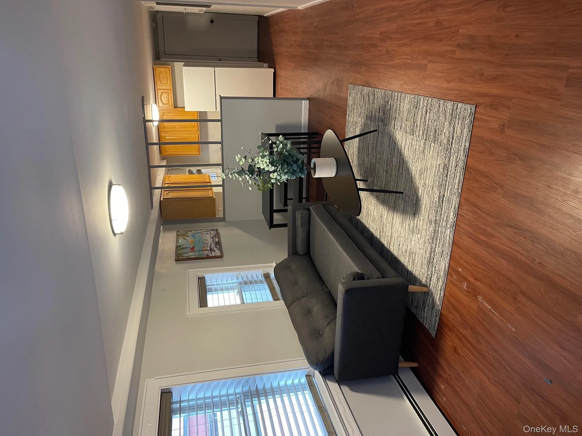 Living room featuring dark wood-type flooring, a baseboard heating unit, and plenty of natural light Living room featuring dark wood-type flooring, a baseboard heating unit, and plenty of natural light
