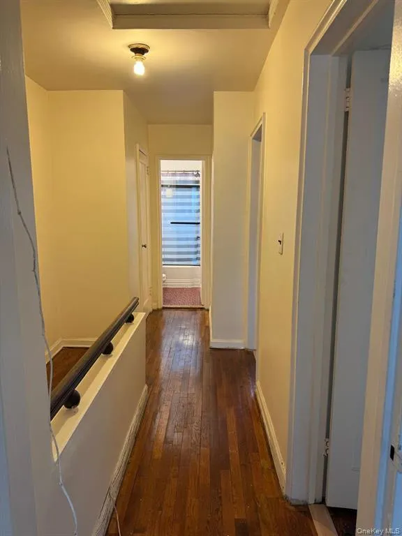 Corridor with dark wood-style floors and baseboards Corridor with dark wood-style floors and baseboards