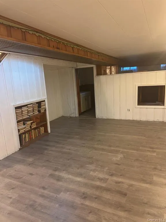 Unfurnished living room with dark wood finished floors and a decorative wall Unfurnished living room with dark wood finished floors and a decorative wall
