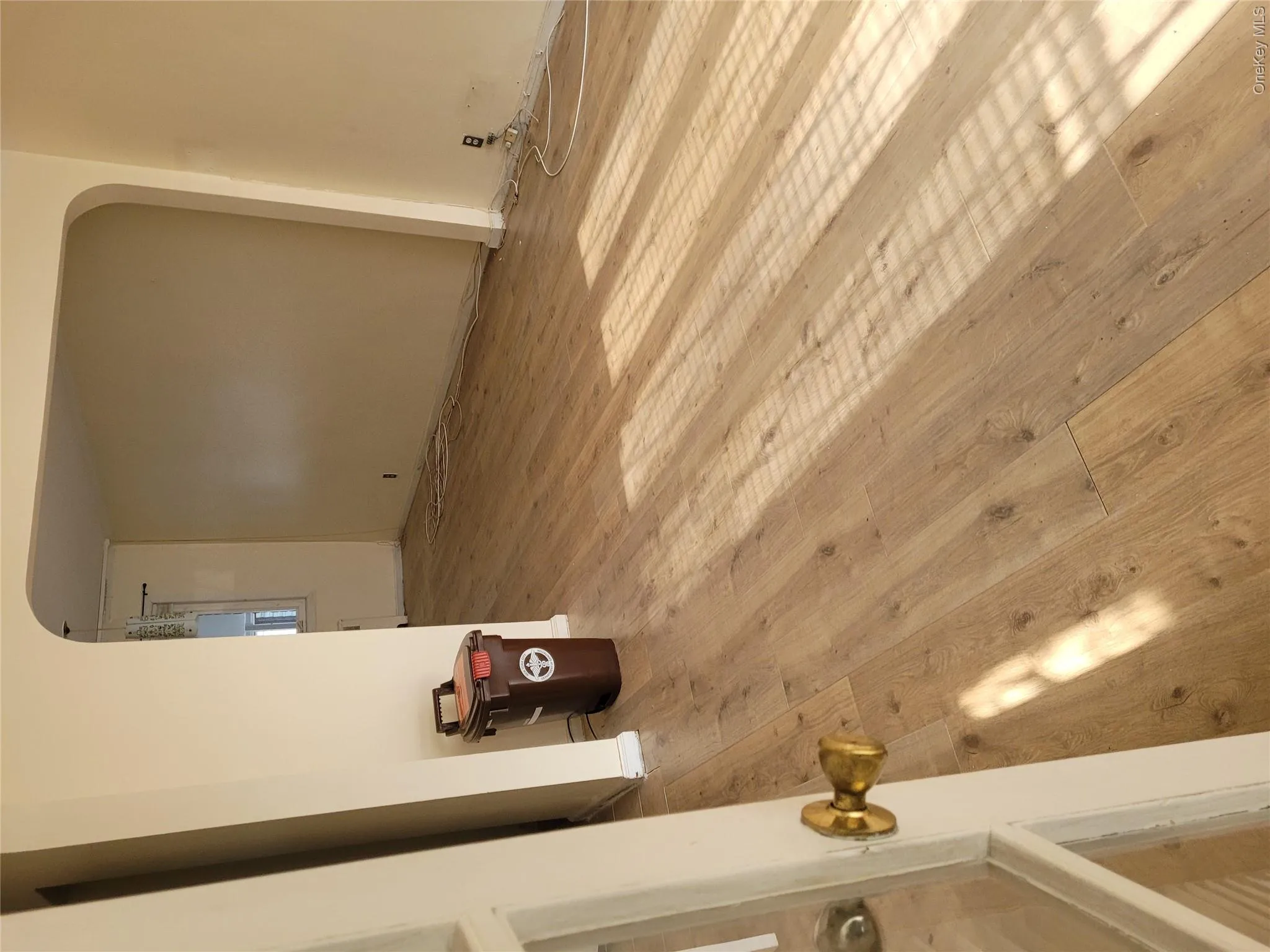 Spare room featuring arched walkways and light wood-style floors Spare room featuring arched walkways and light wood-style floors