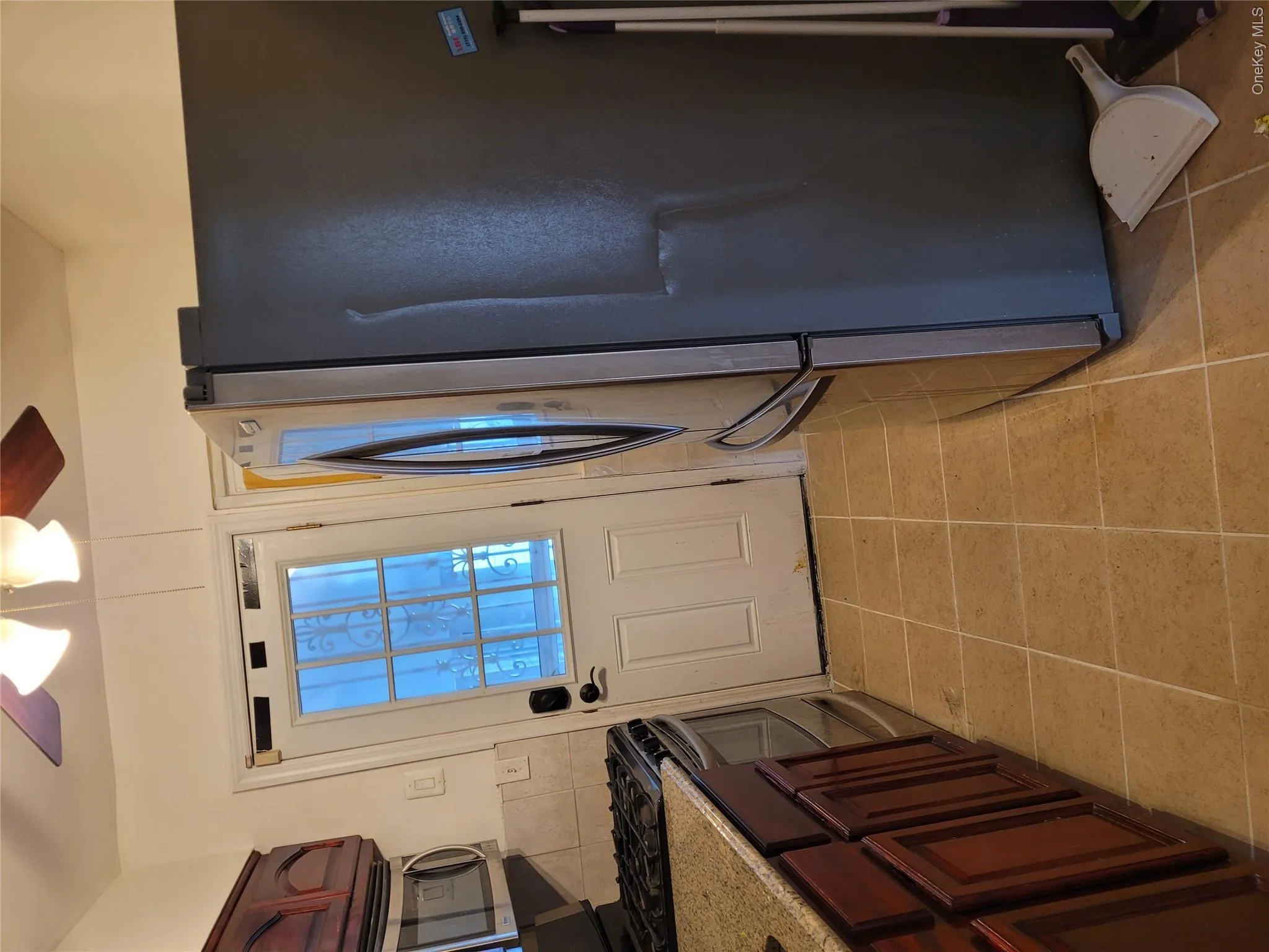 Kitchen with freestanding refrigerator, range, ceiling fan, and light tile patterned floors Kitchen with freestanding refrigerator, range, ceiling fan, and light tile patterned floors