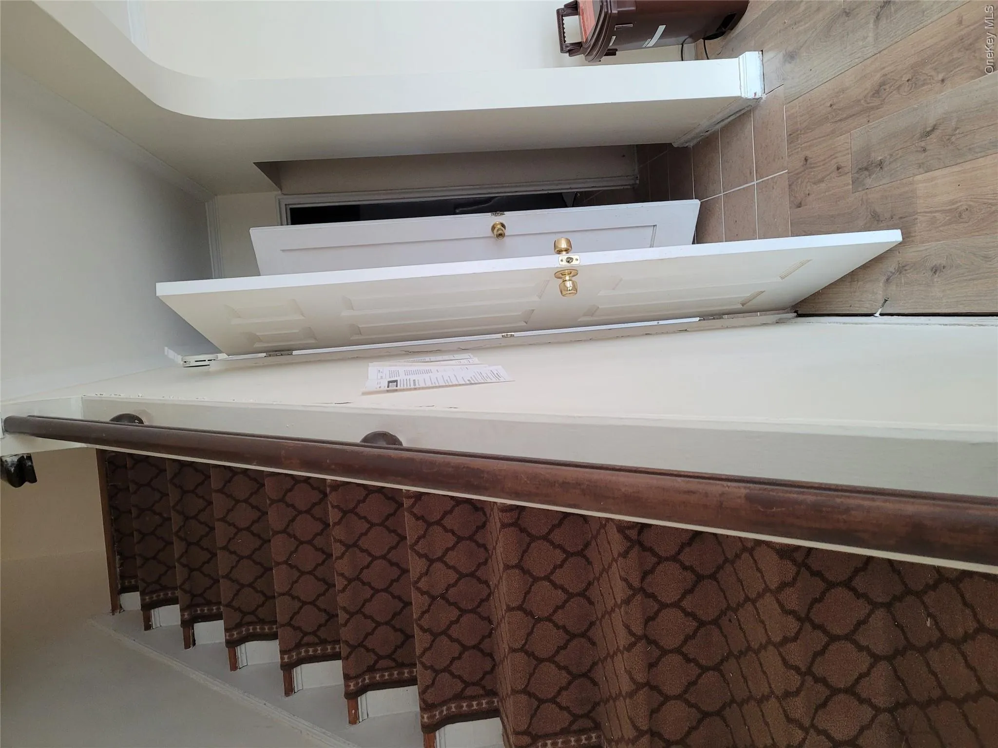 Stairs featuring wood finished floors and arched walkways Stairs featuring wood finished floors and arched walkways
