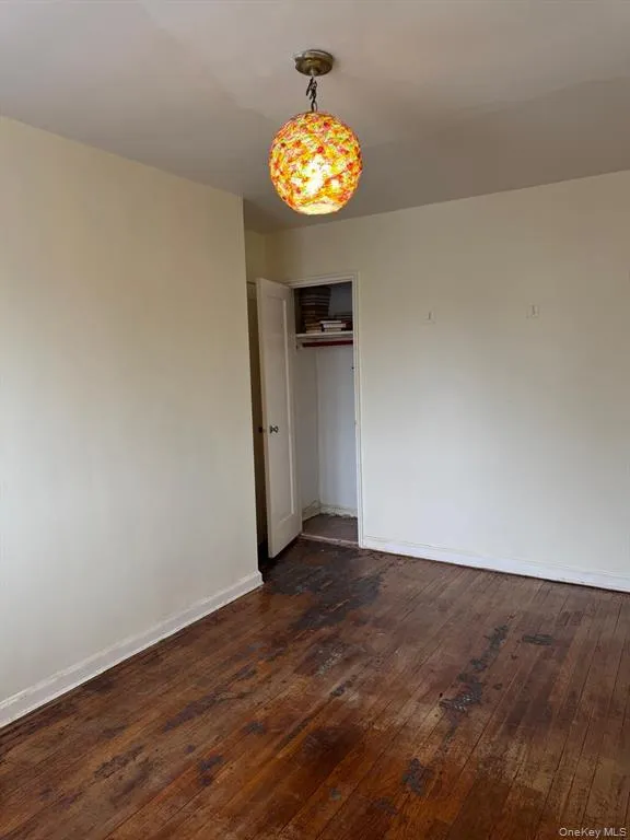 Unfurnished bedroom with a closet and dark wood finished floors Unfurnished bedroom with a closet and dark wood finished floors