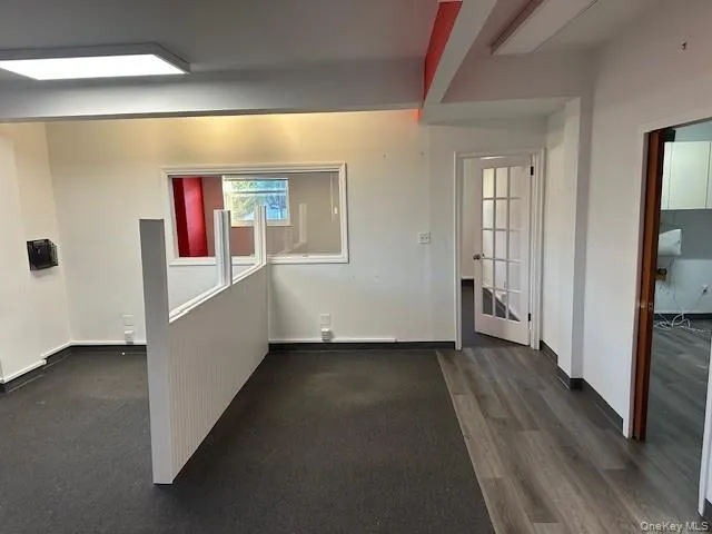 Corridor with baseboards and dark wood-style floors Corridor with baseboards and dark wood-style floors